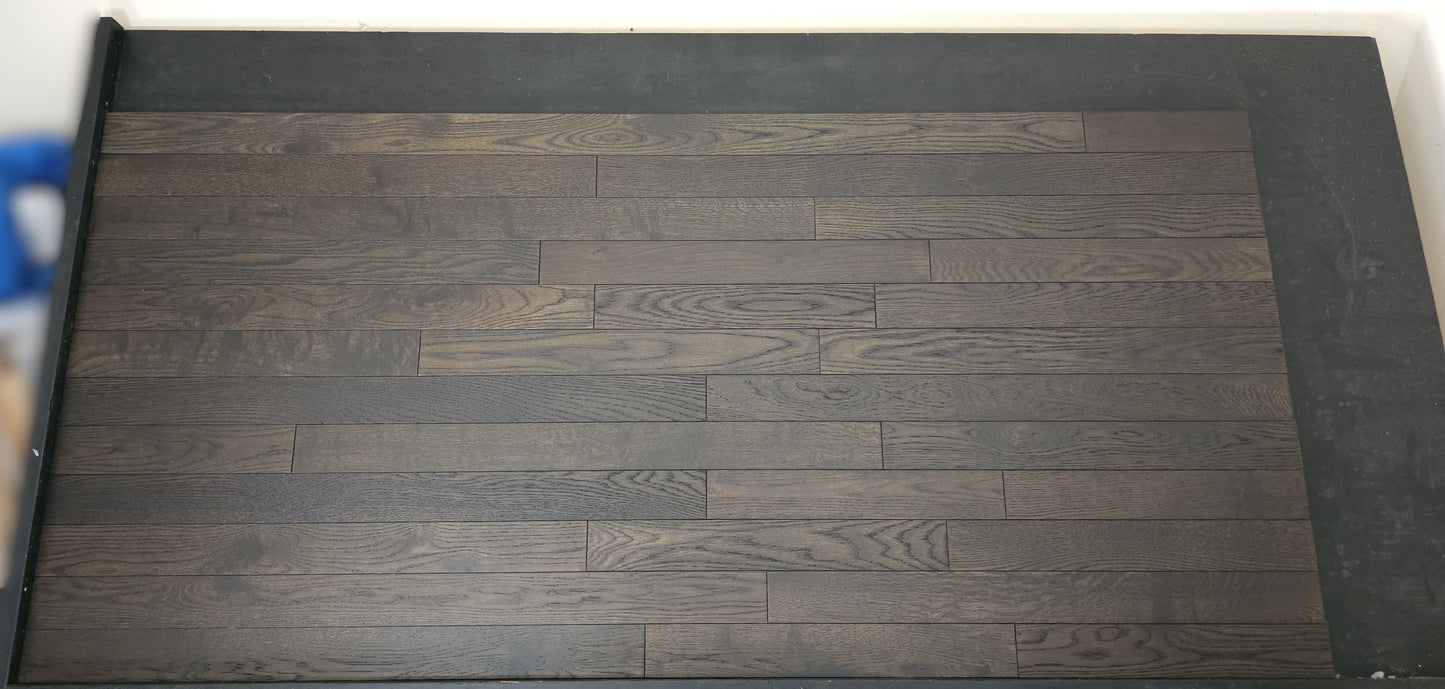 3 1/4" x 3/4" Solid White Oak Charcoal Hardwood Flooring. Shown on a black shooting table. Shot from Center.