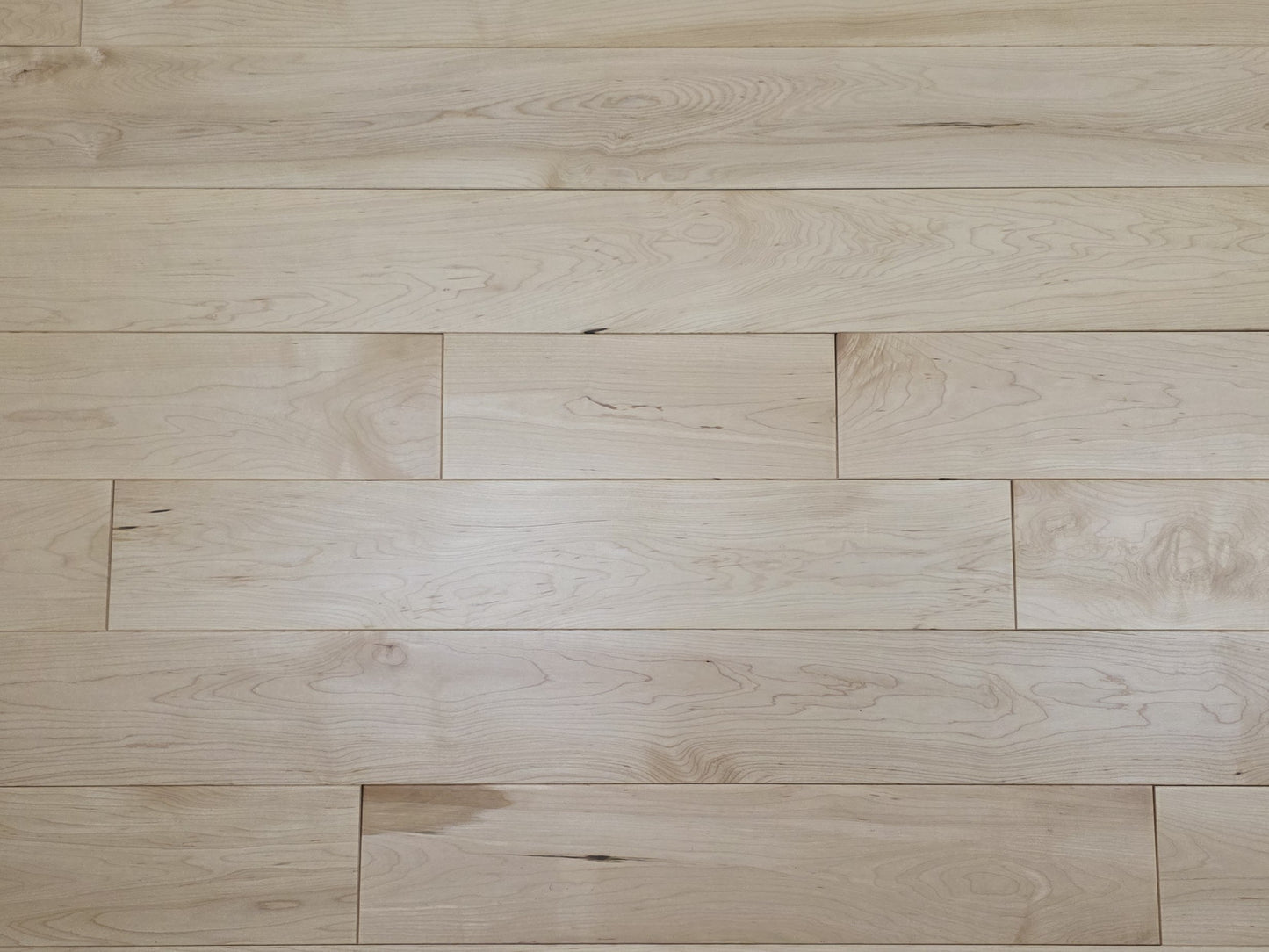 Maple HardWood flooring with a light brown color and visible grain pattern.