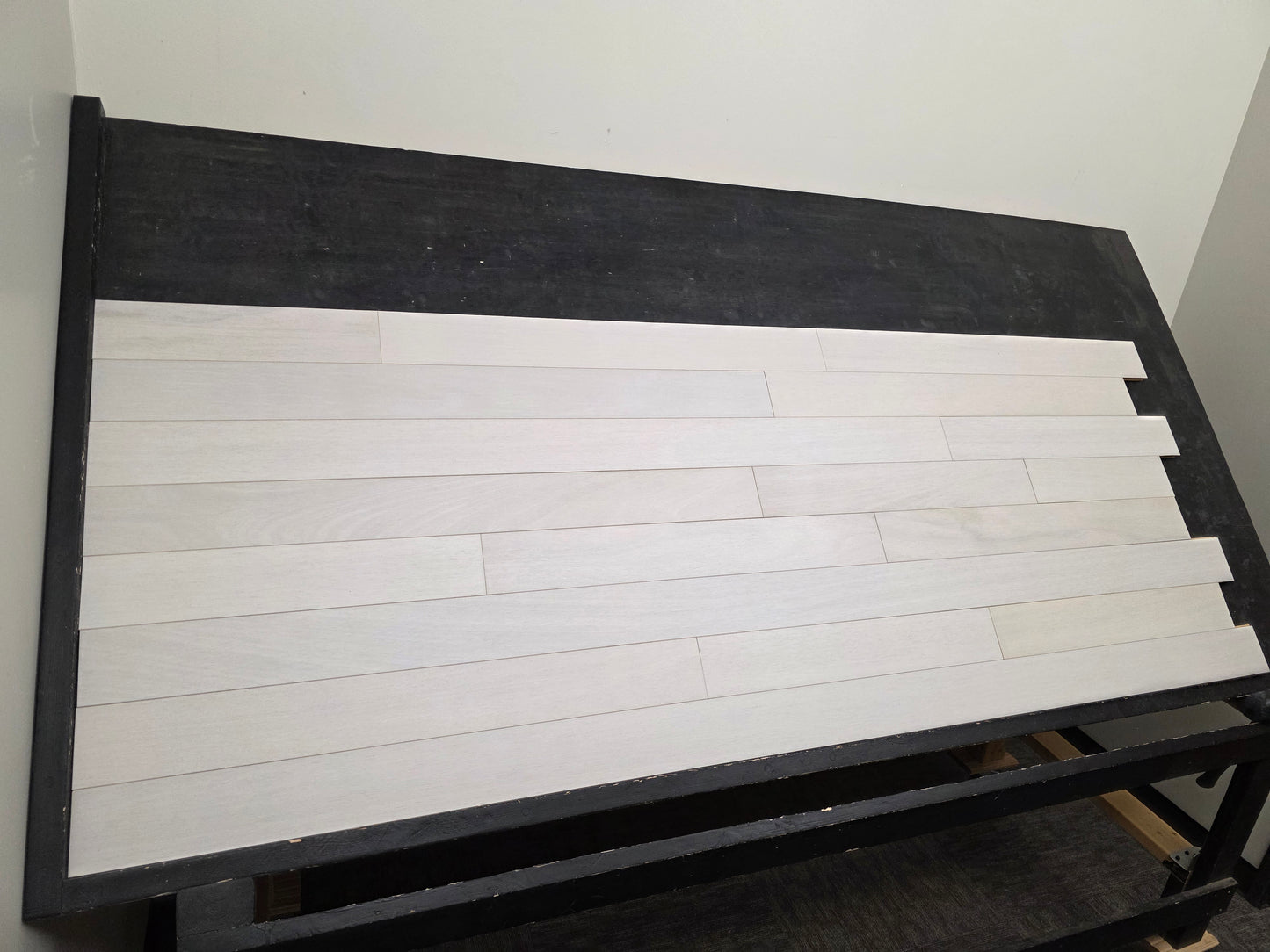 4" x 3/4" Solid Brazilian Oak Urso Hardwood Flooring on a black shooting table, wide left angle shot.