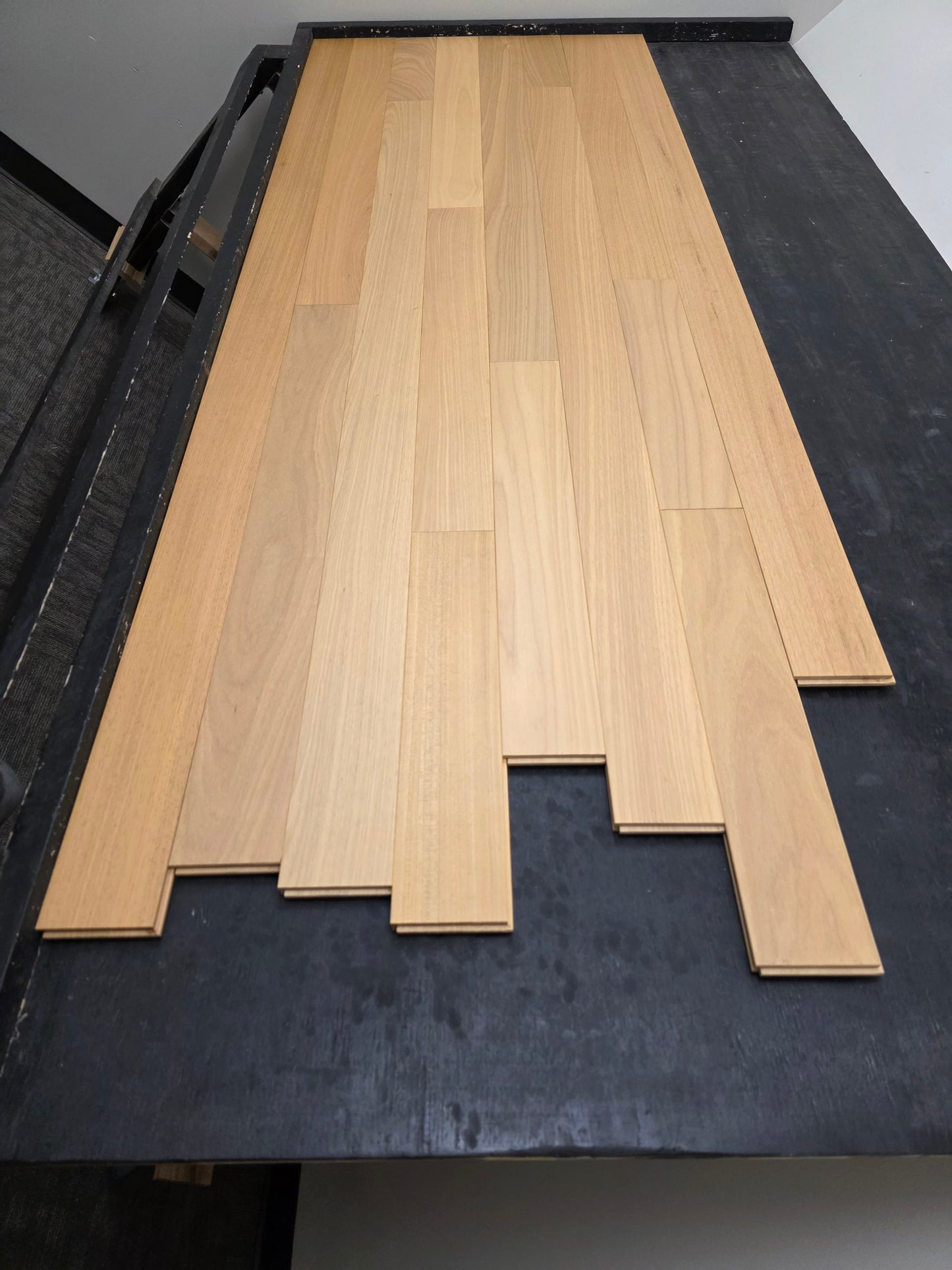 4" x 3/4" Solid Brazilian Oak Natural Hardwood Flooring top down shot on a black rack