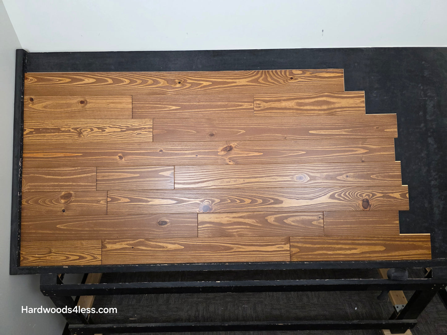 5 1/8" x 3/4" Southern Yellow Pine Nectar Solid Hardwood Flooring. Shown  on a black shooting rack. Shot from the center.