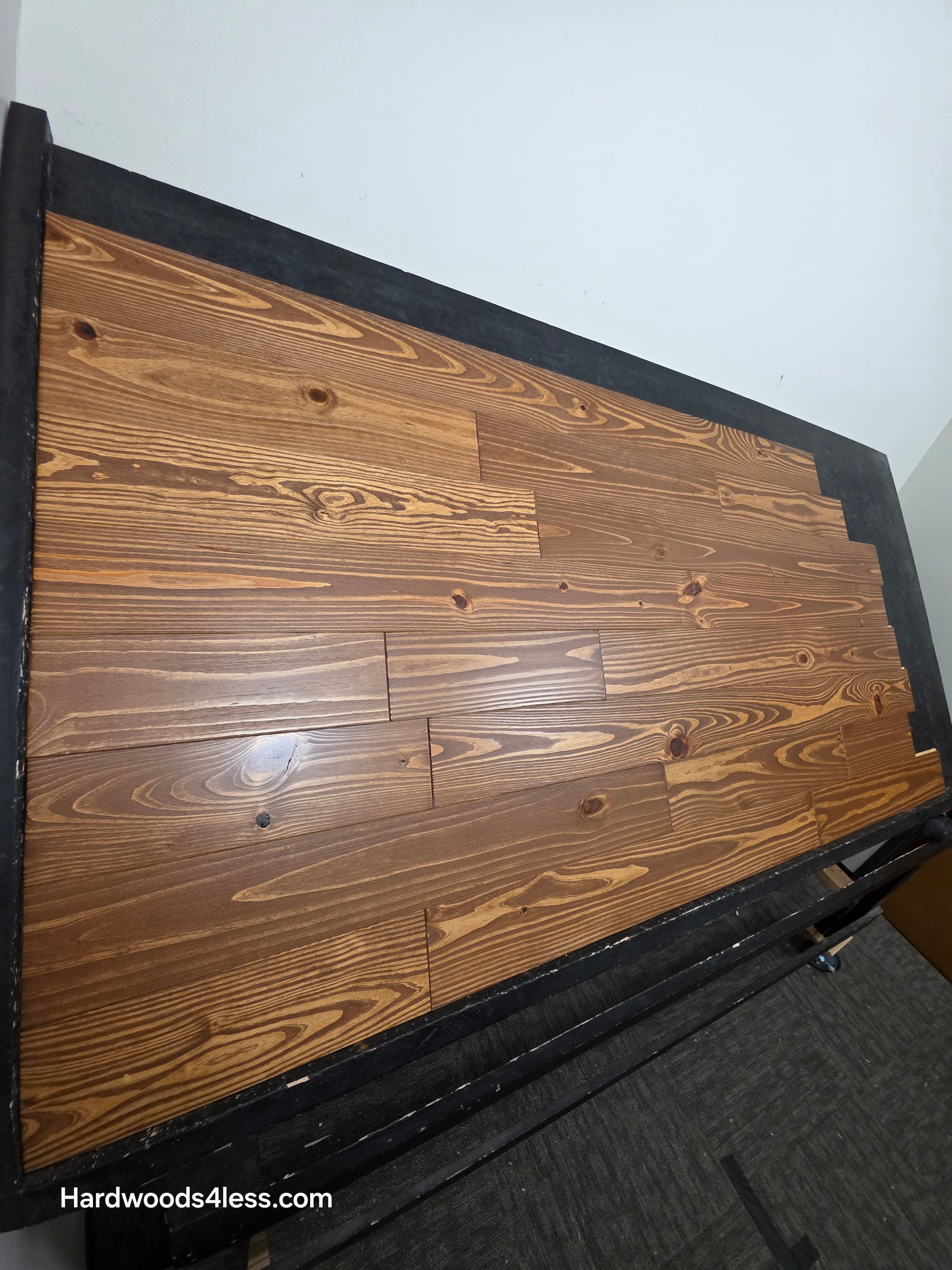 5 1/8" x 3/4" Southern Yellow Pine Nectar Solid Hardwood Flooring. Shown  on a black shooting rack. Shot from the left hand side.