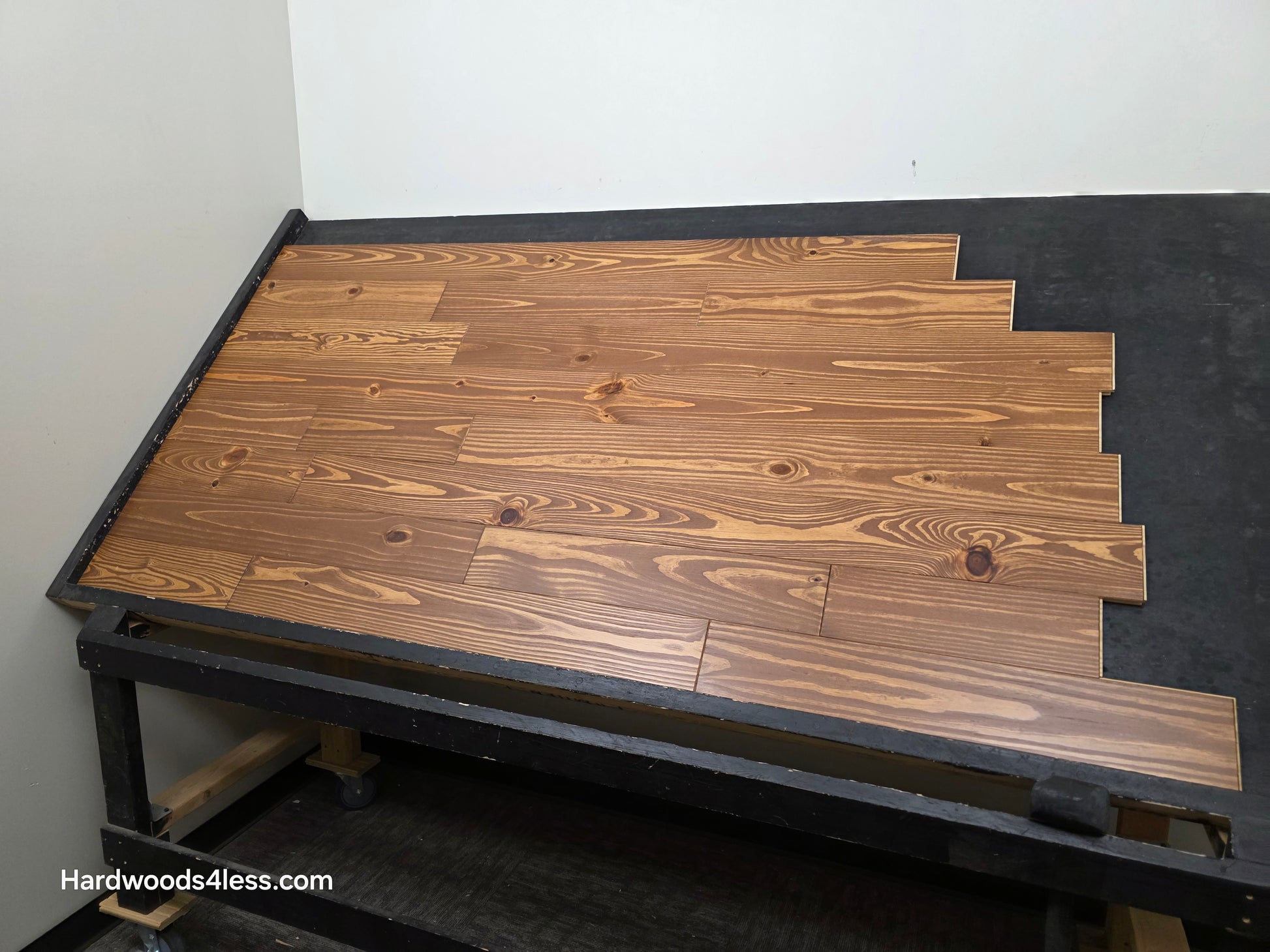 5 1/8" x 3/4" Southern Yellow Pine Nectar Solid Hardwood Flooring. Shown  on a black shooting rack.  Shot from the right hand side.