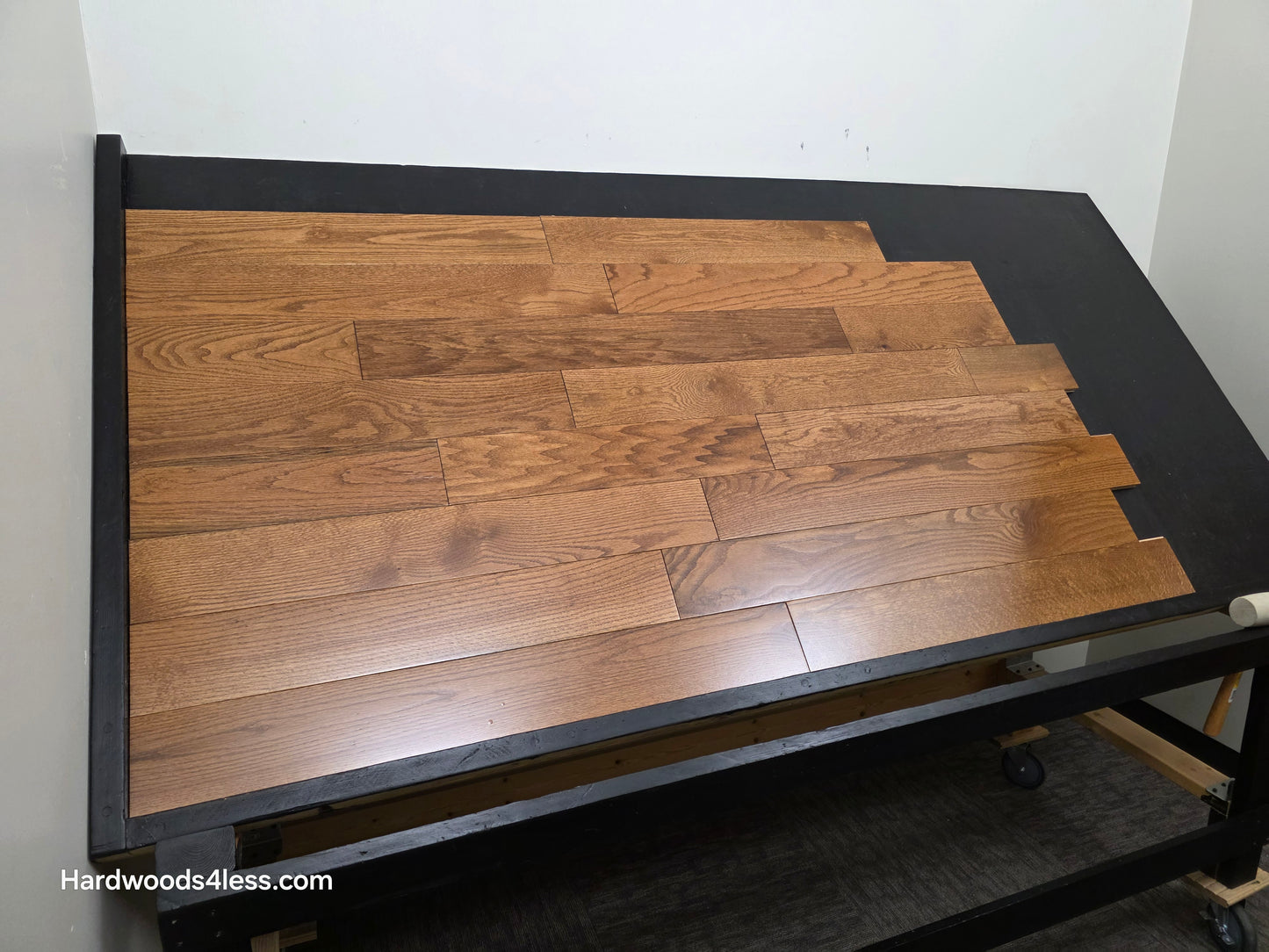 5 x 34 Solid Red Oak Hide Hardwood Flooring. Shown on a black shooting table. Shot from wide left.