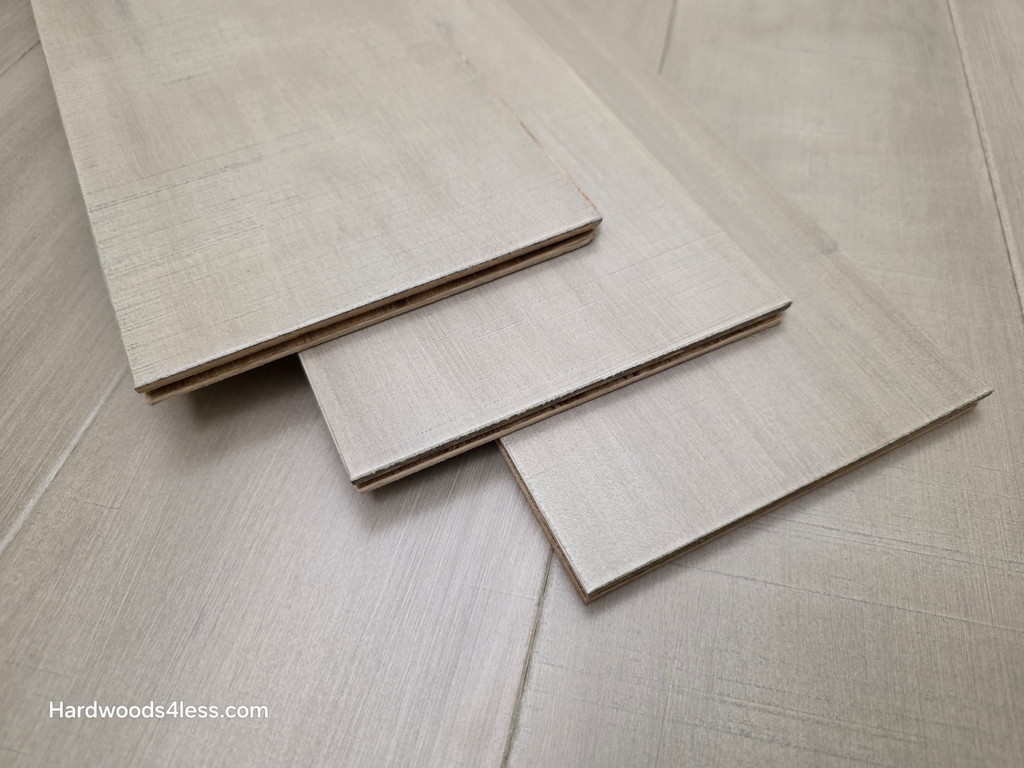 6 1/2" x 1/2" Engineered Maple Polar Palace Hardwood Flooring shown with three boards stacked on top of the flooring.