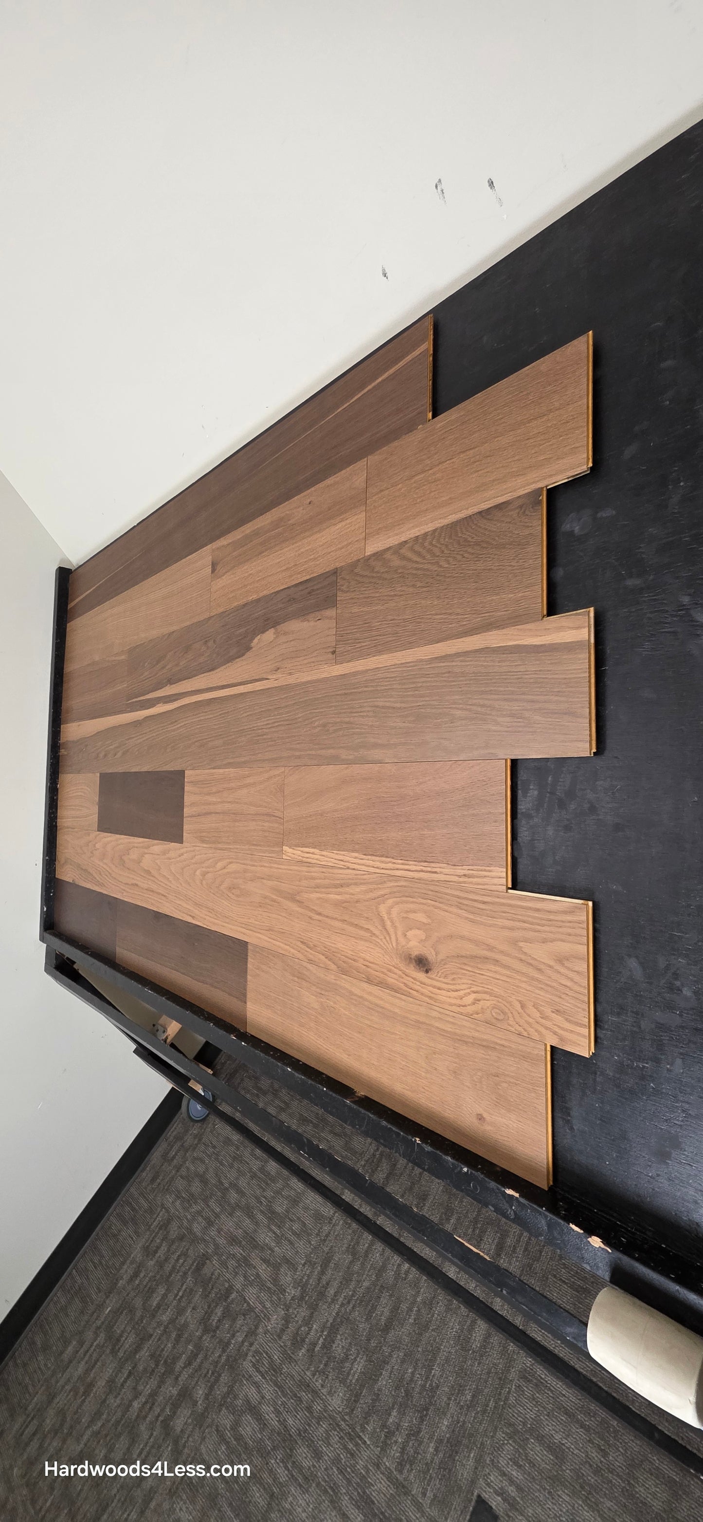 6 1/2" x 7/16" Engineered White Oak Wingham Hardwood Flooring. Shown on a black shooting table. Shot from steep right.