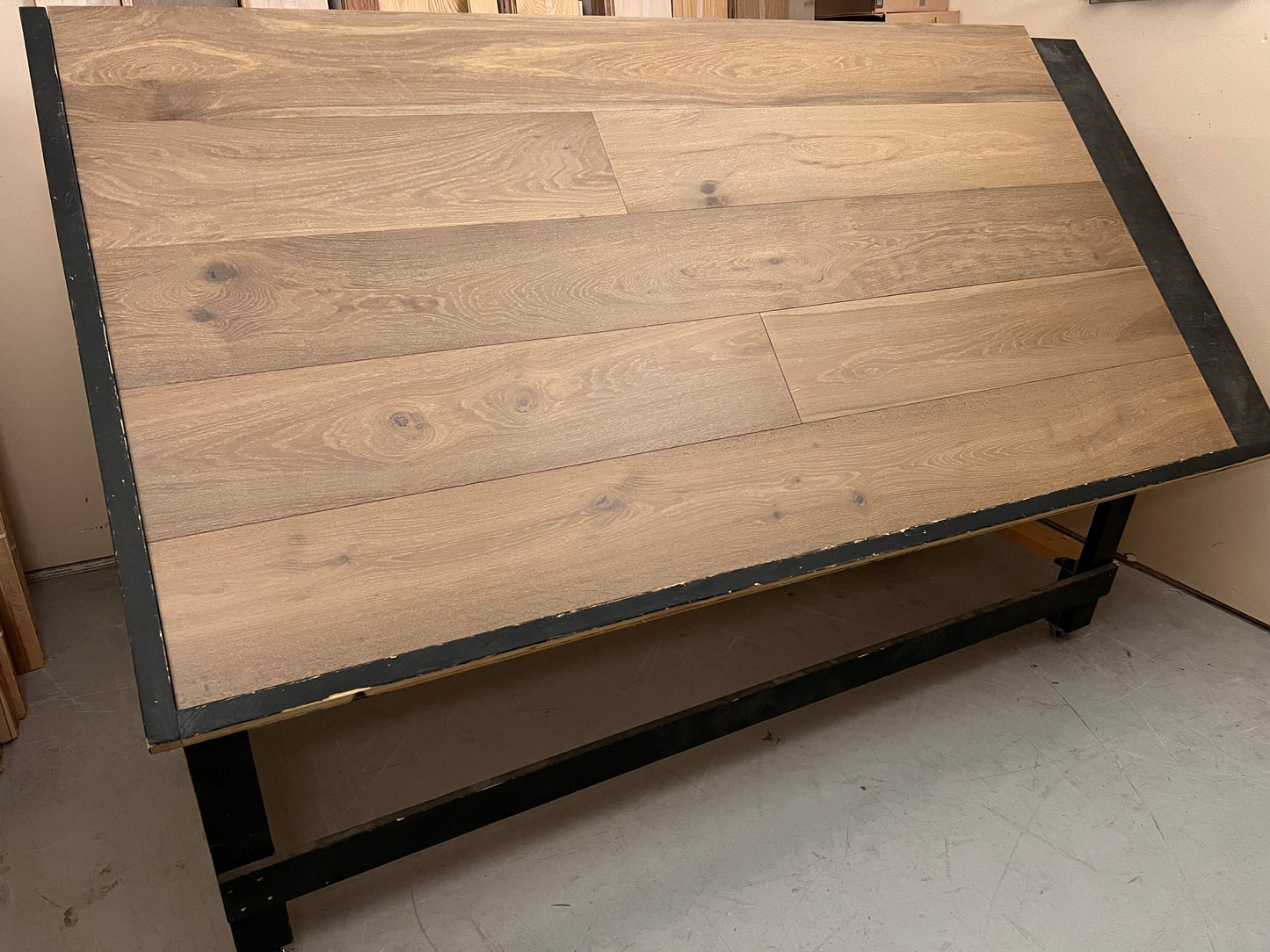 9 1/2" x 5/8" Engineered European Oak Flathead (Pelister) Hardwood Flooring. Shown on a black shooting table. shot from wide left.