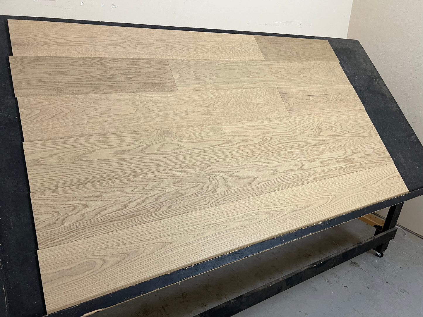 7 1/2" x 3/8" Engineered White Oak Dolce Hardwood Flooring shown on a black shooting rack. Shot from the left side