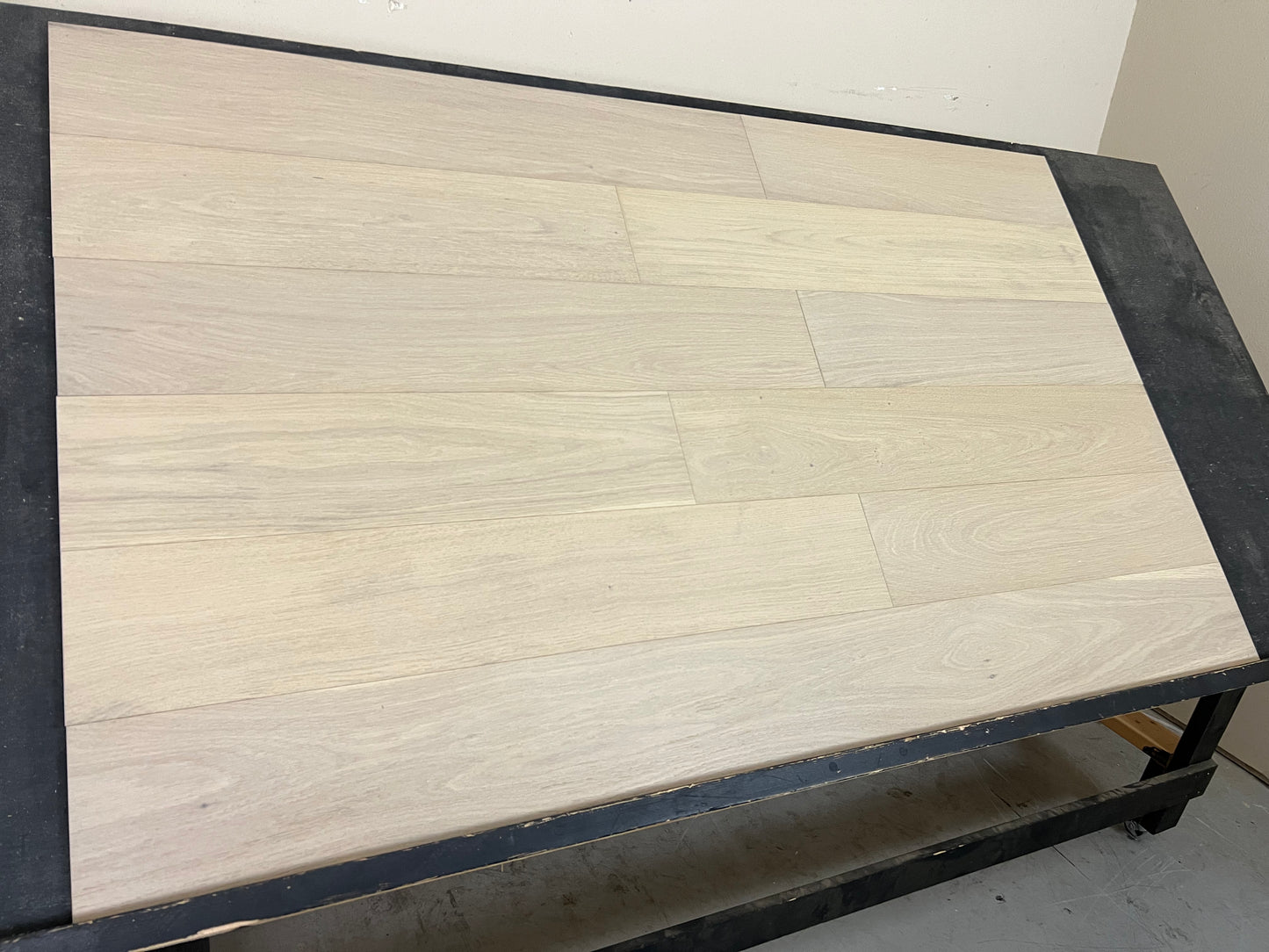 7 1/2" x 3/8" Engineered White Oak Mia Hardwood Flooring shown on a black shooting rack. Shot from the left hand side.