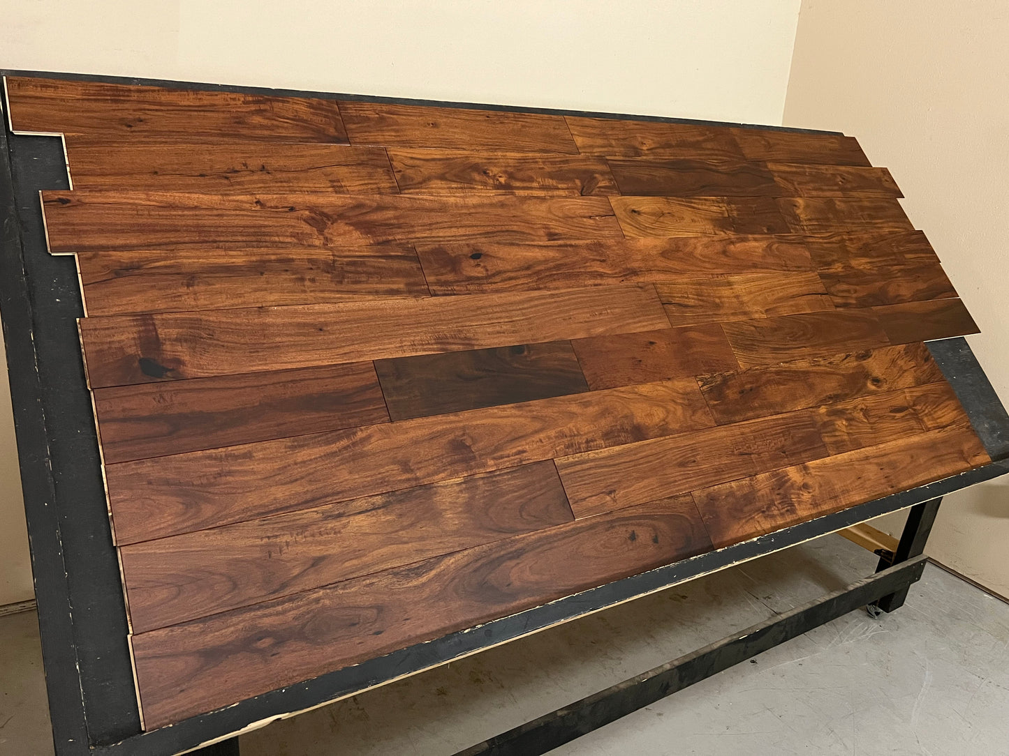 5" x 1/2" Engineered Acacia Caillebotte Hardwood Flooring. Shown on black shooting table. Shot from the left hand side.
