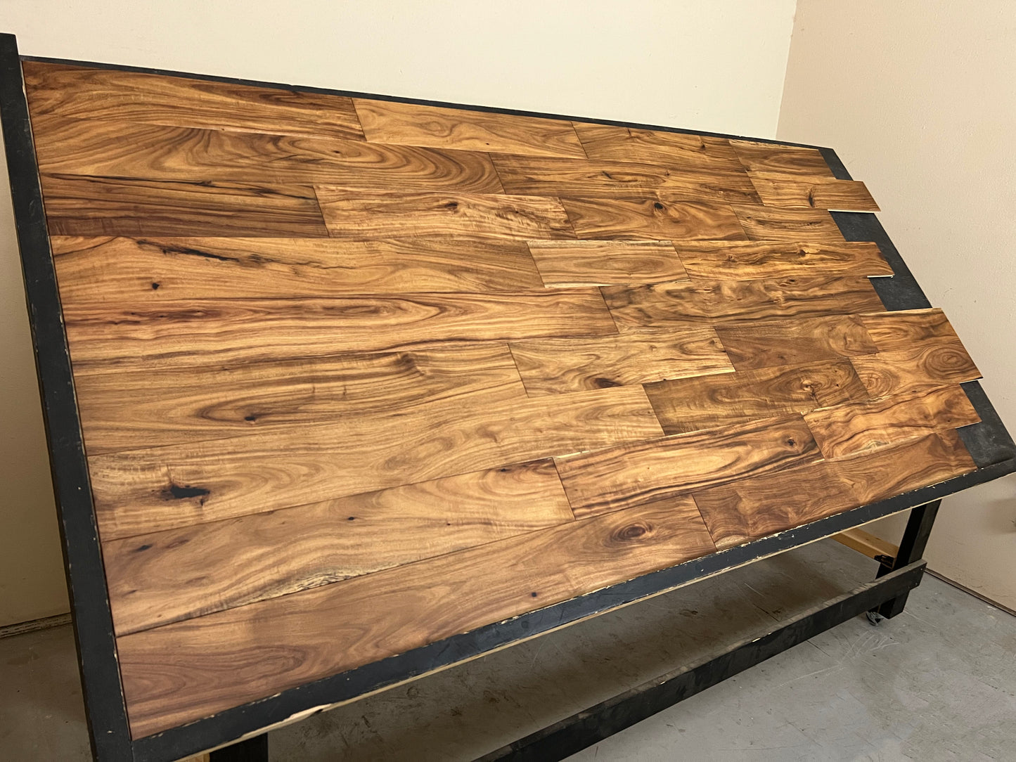 5" x 1/2" Engineered Acacia Cezanne Hardwood Flooring. Shown on a black shooting table. shot from the left hand side