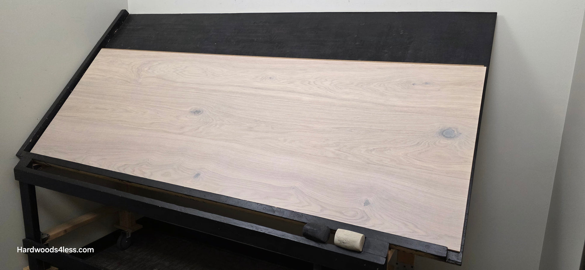 10.67" x 7/16" Modernized Engineered European Oak Corbusier Hardened Hardwood Flooring. Shown on a black shooting table. Shot from wide left.