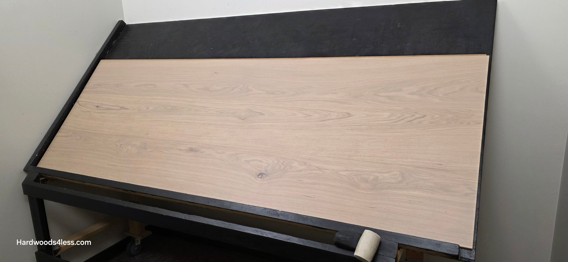 10.67" x 7/16" Modernized Engineered European Oak Foster Hardwood Flooring. Shown on a black shooting table. Shot from wide right. This is a Laminate look alike. 