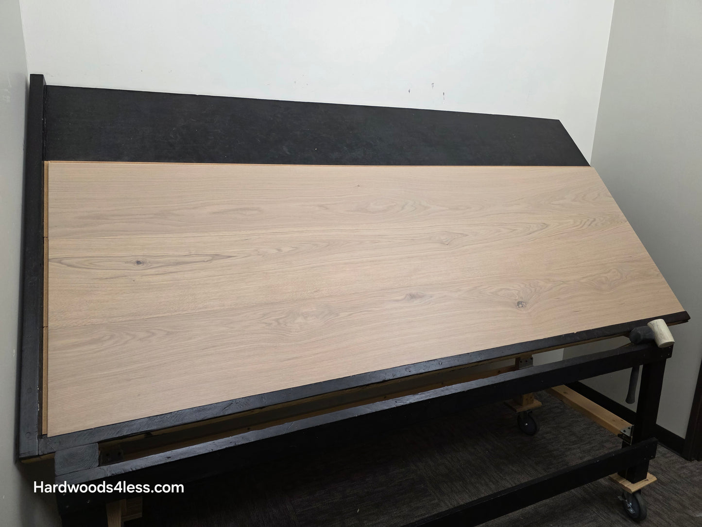 10.67" x 7/16" Modernized Engineered European Oak Foster Hardwood Flooring. Shown on a black shooting table. Shot from wide left. This is a Laminate look alike. 