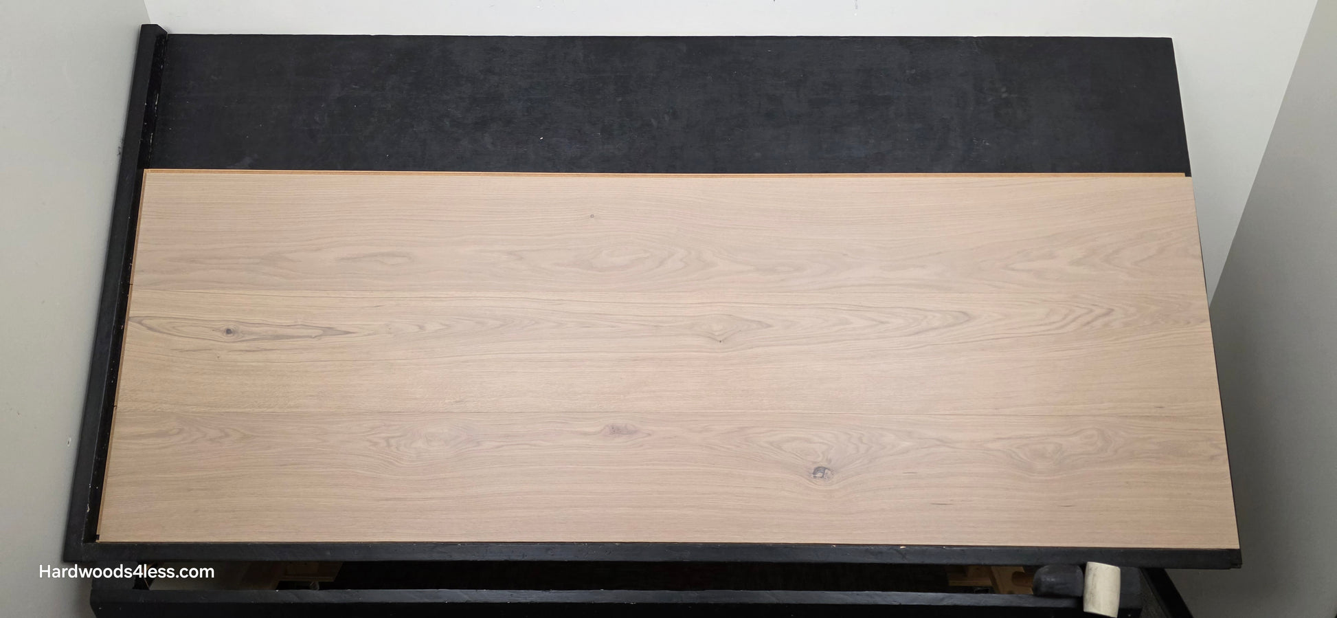 10.67" x 7/16" Modernized Engineered European Oak Foster Hardwood Flooring. Shown on a black shooting table. Shot from center. This is a Laminate look alike. 