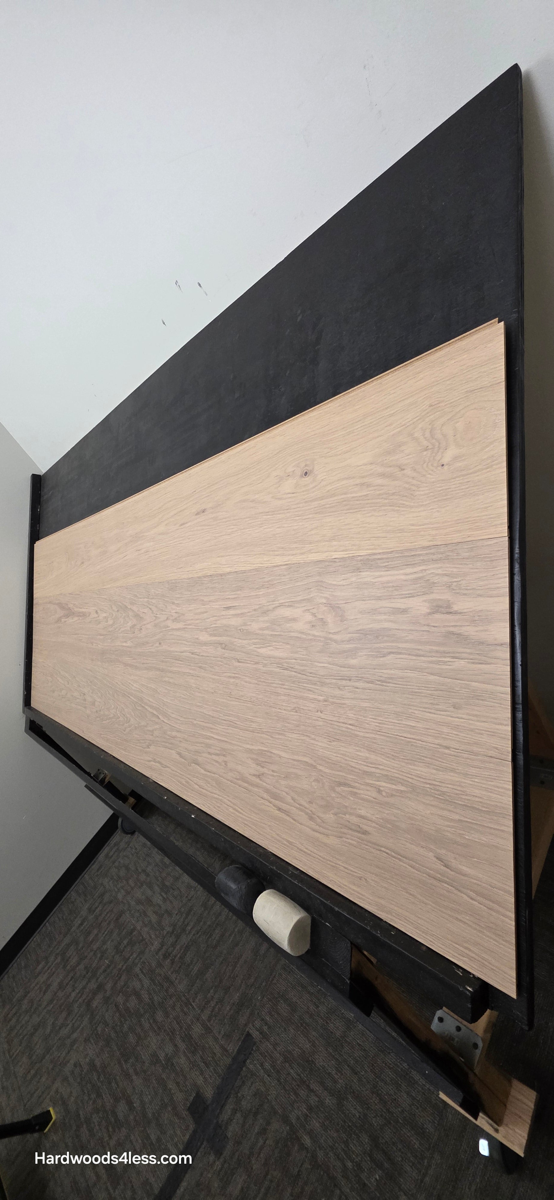 10.67" x 7/16" Modernized Engineered European Oak Gropius Hardened Hardwood Flooring. Shown on a black shooting table. Shot from steep right. 