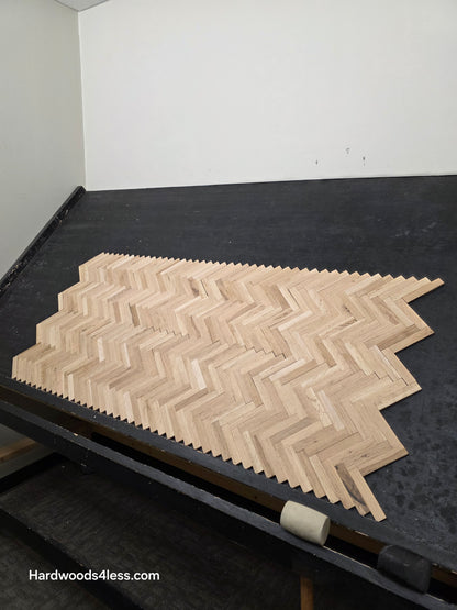 14 1/8" x 18 1/8" x 5/16" Unfinished White Oak Herringbone Parquet Flooring. 6 tiles wide on a black shooting table.