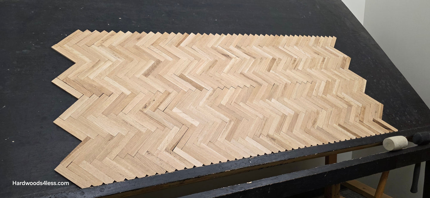 14 1/8" x 18 1/8" x 5/16" Unfinished White Oak Herringbone Parquet Flooring. 6 tiles wide on a black shooting table.