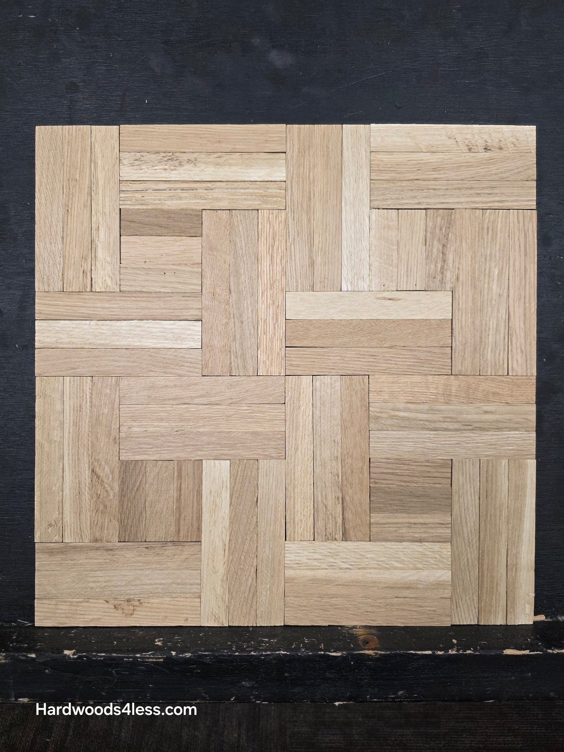 14 ¼ x 14 ¼ x 5/16 Unfinished White Oak Haddon Hall Parquet Flooring. Shown on a black shooting table. Close up. 