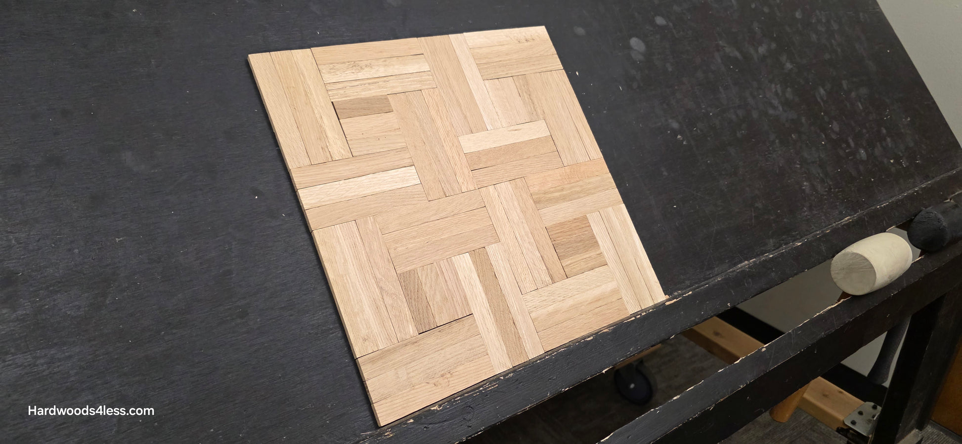 14 ¼ x 14 ¼ x 5/16 Unfinished White Oak Haddon Hall Parquet Flooring. Shown on a black shooting table. Wide lens Close up. 
