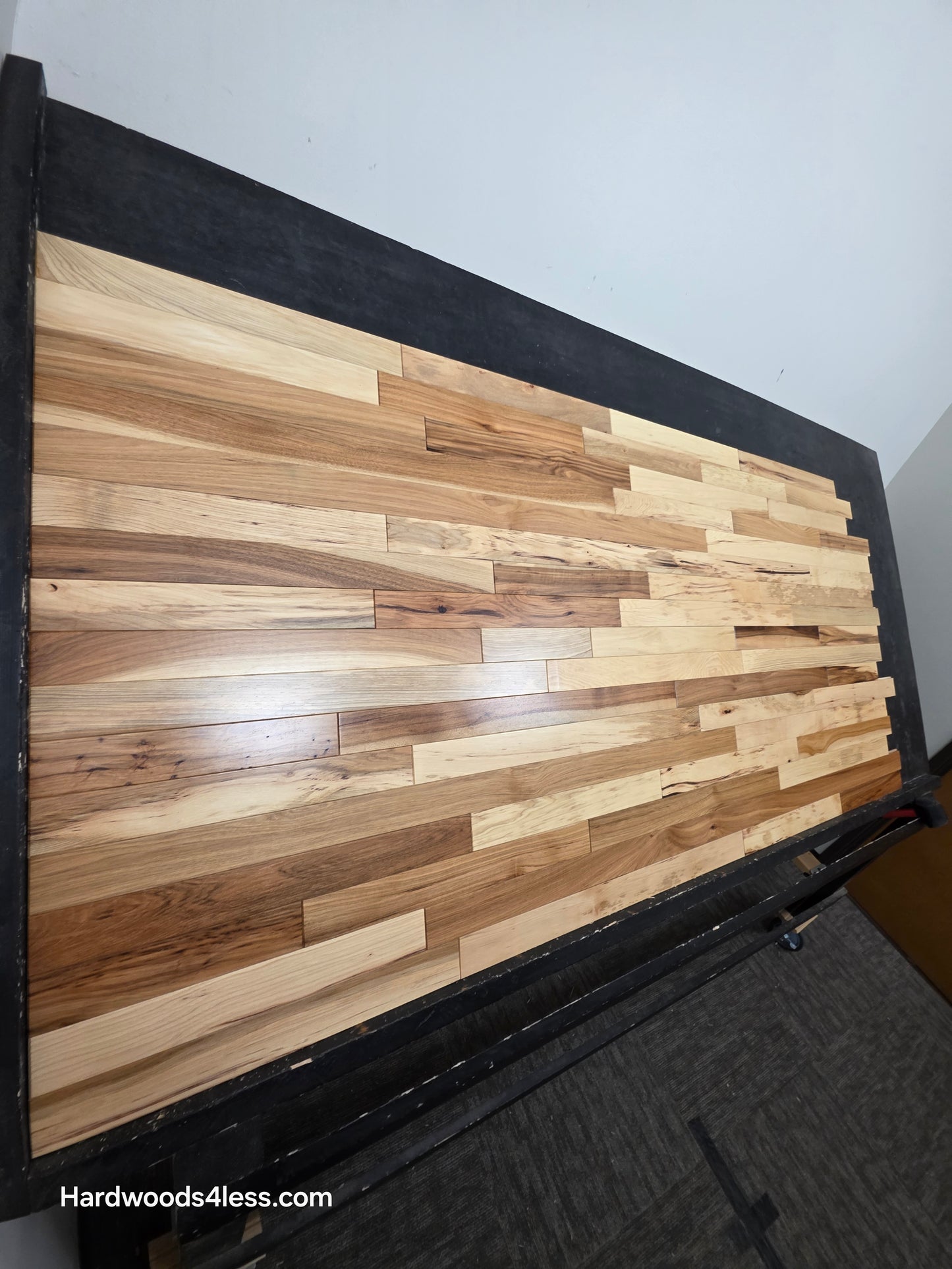 2 1/4" x 3/4" Hickory Natural Character Grade Hardwood Flooring.  Shown on a black shooting table shot from the left hand side. 