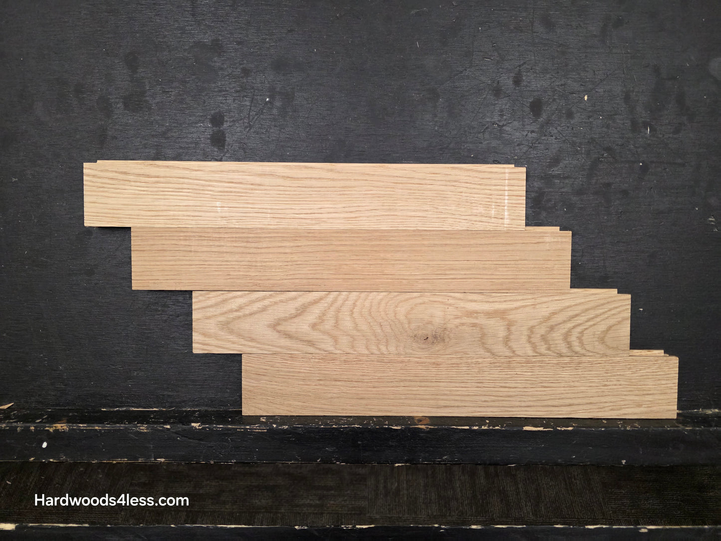 2 14 x 15.75 x 34 Solid Unfinished White Oak Herringbone Hardwood Flooring. Shown on a black shooting table. depicted as 4 planks stacked horizontally.
