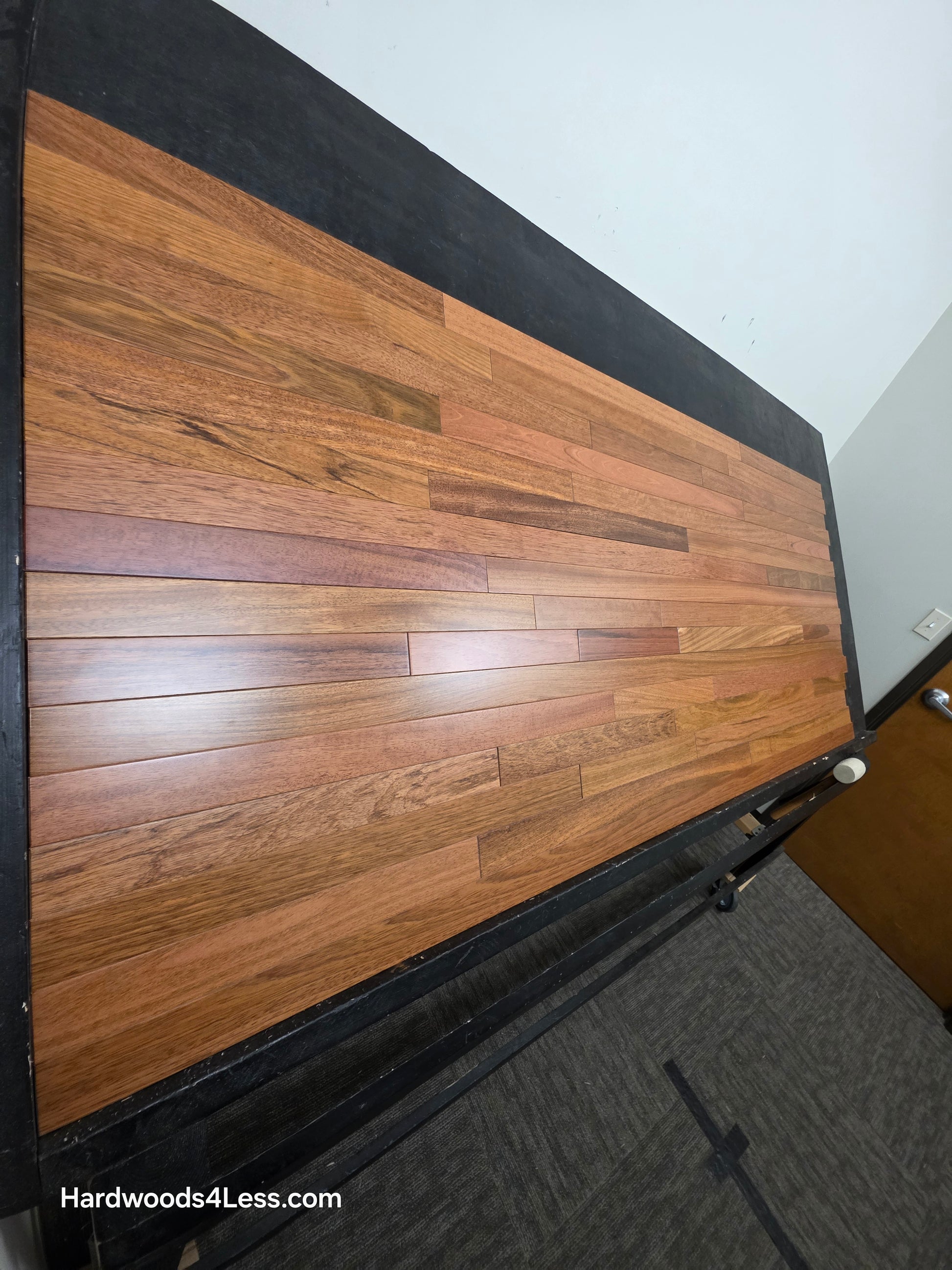 2 1/4" x 3/4" Brazilian Cherry Hardwood Flooring. Shown on a black shooting table. Shot from steep left. 