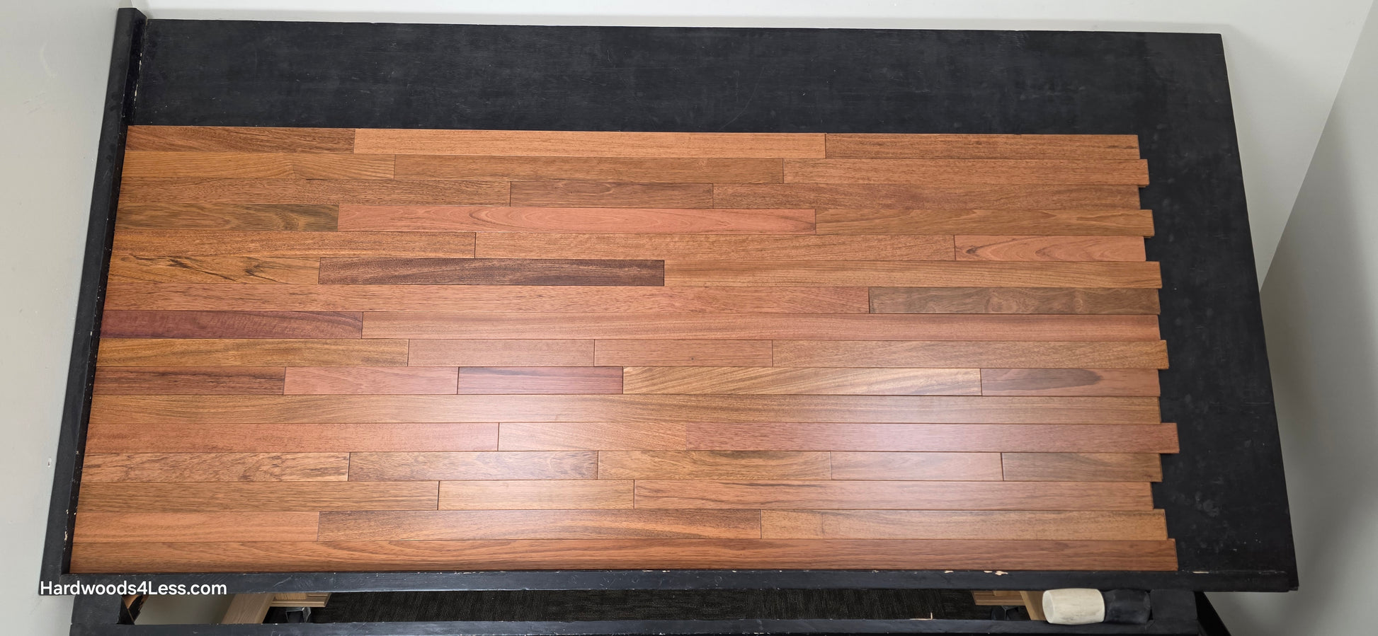 2 1/4" x 3/4" Brazilian Cherry Hardwood Flooring. Shown on a black shooting table. Shot from center.