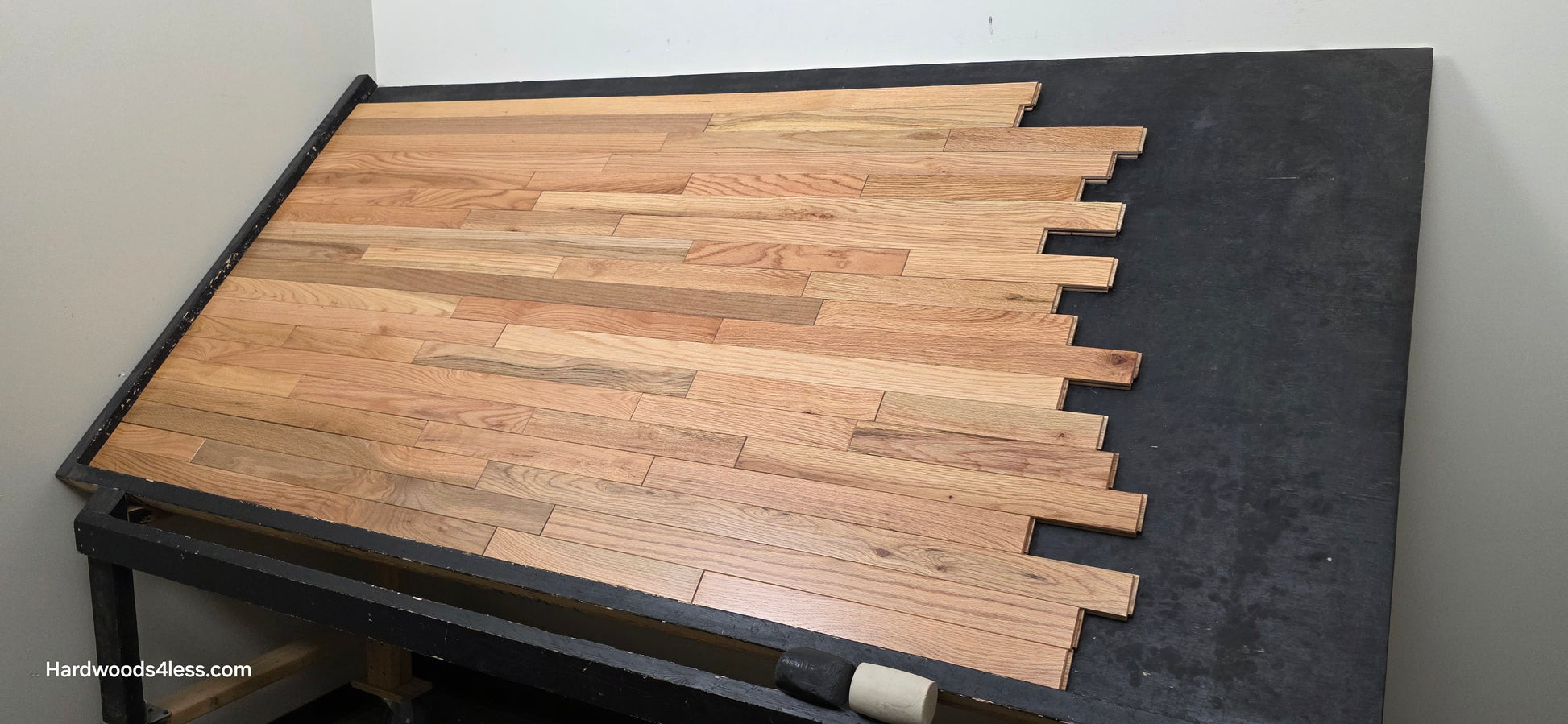 2 1/4" x 3/4" Solid Red Oak Natural Mill Run Hardwood Flooring Shown on a black shooting table. Shot from corner right. 