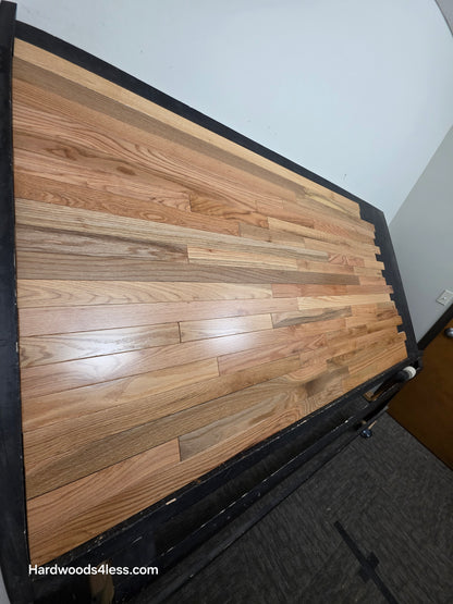 2 1/4" x 3/4" Solid Red Oak Natural Mill Run Hardwood Flooring Shown on a black shooting table. Shot from steep left.