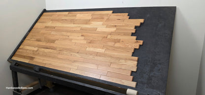 2 1/4" x 3/4" Solid White Oak Natural Mill Run Hardwood Flooring. Shown on a black shooting table. Shot from wide right.