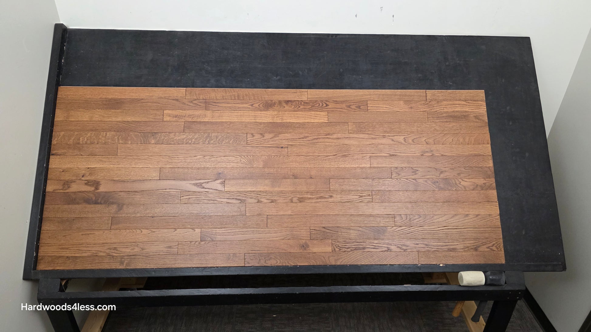 2 1/4" x 3/4" White Oak Gunstock Hardwood Flooring. Shown on a black shooting table. Shot from center.