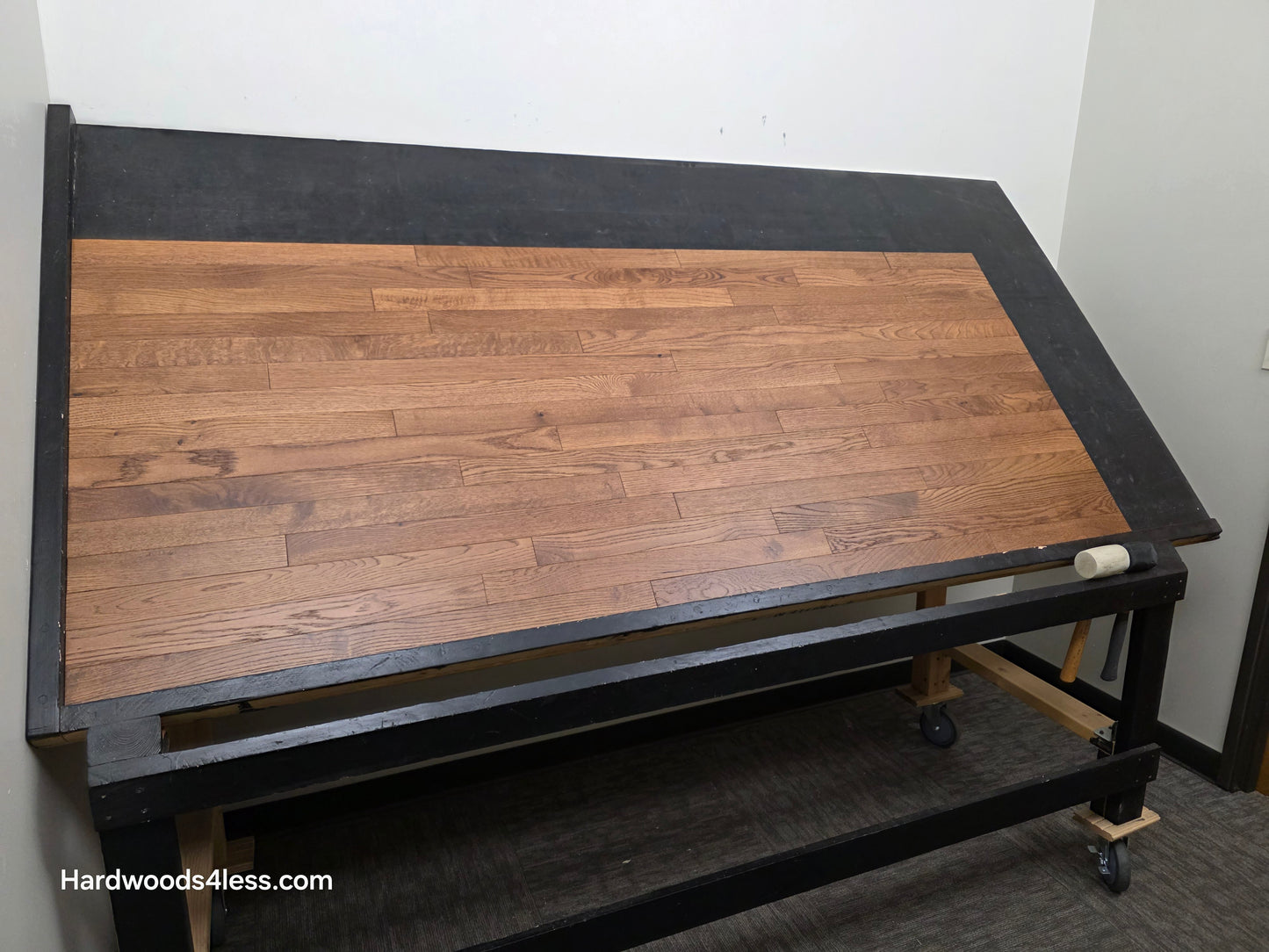 2 1/4" x 3/4" White Oak Gunstock Hardwood Flooring. Shown on a black shooting table. Shot from wide left.