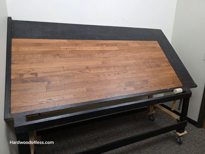 2 1/4" x 3/4" White Oak Gunstock Hardwood Flooring. Shown on a black shooting table. Shot from wide left.