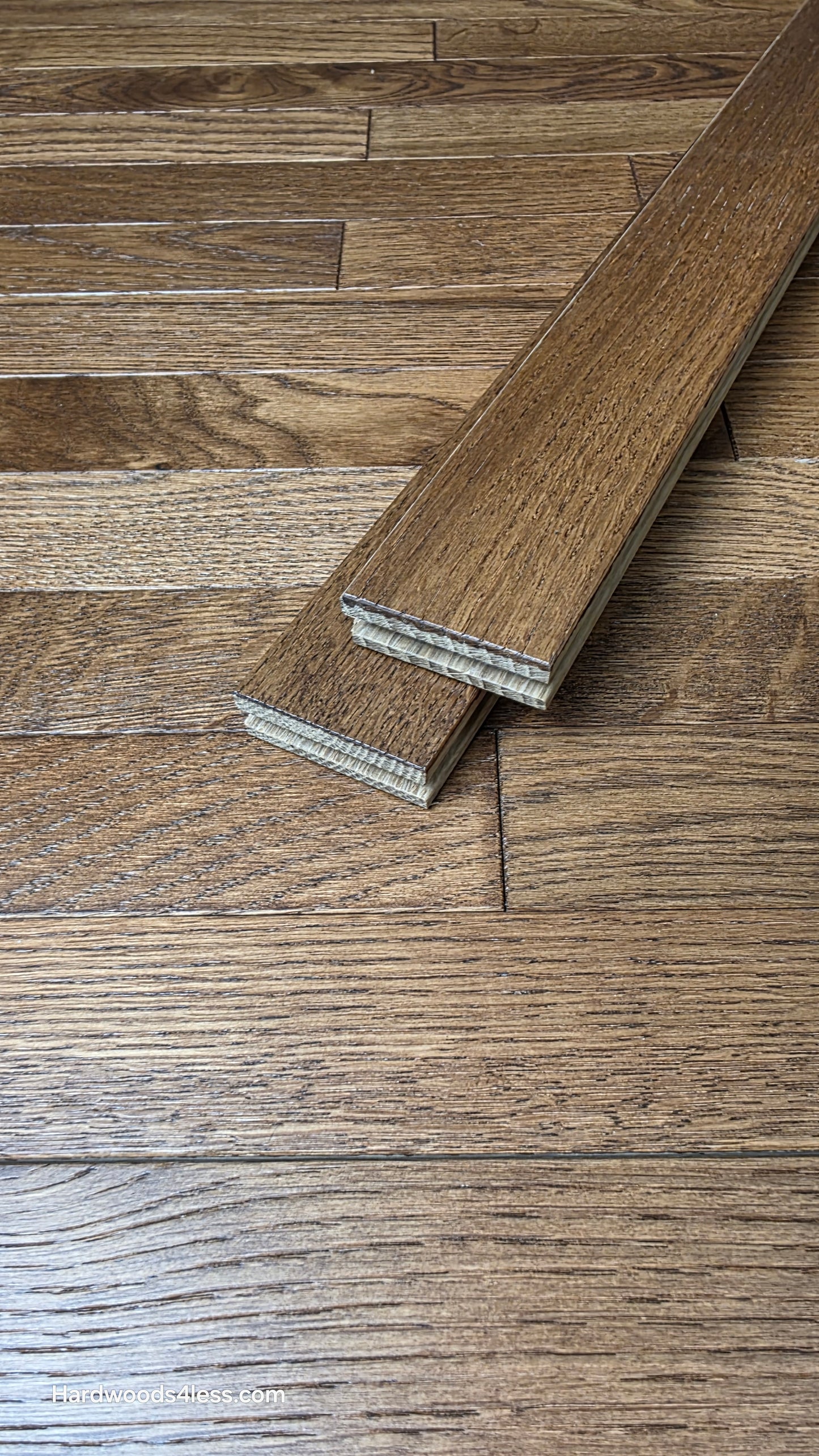 2 1/4" x 3/4" White Oak Gunstock Hardwood Flooring. shown as two boards stacked on top of the floor Hardwood floor. 