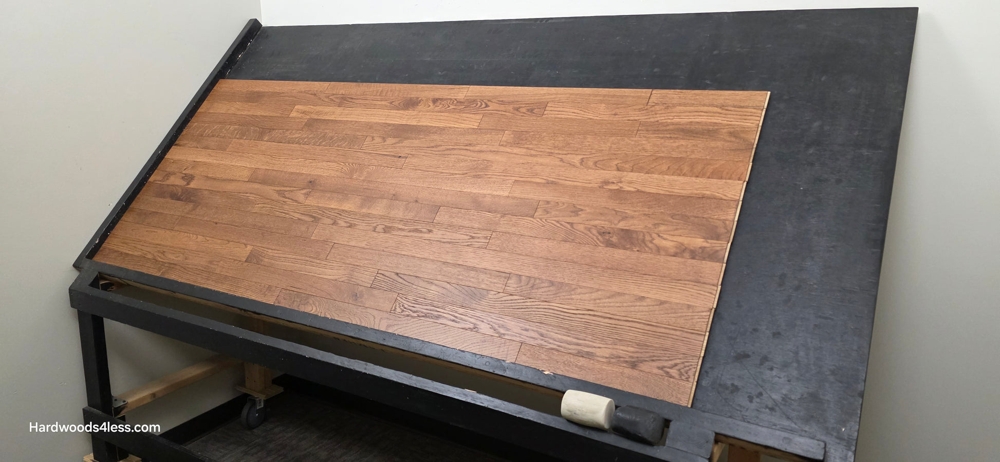 2 1/4" x 3/4" White Oak Gunstock Hardwood Flooring. Shown on a black shooting table. Shot from wide right.