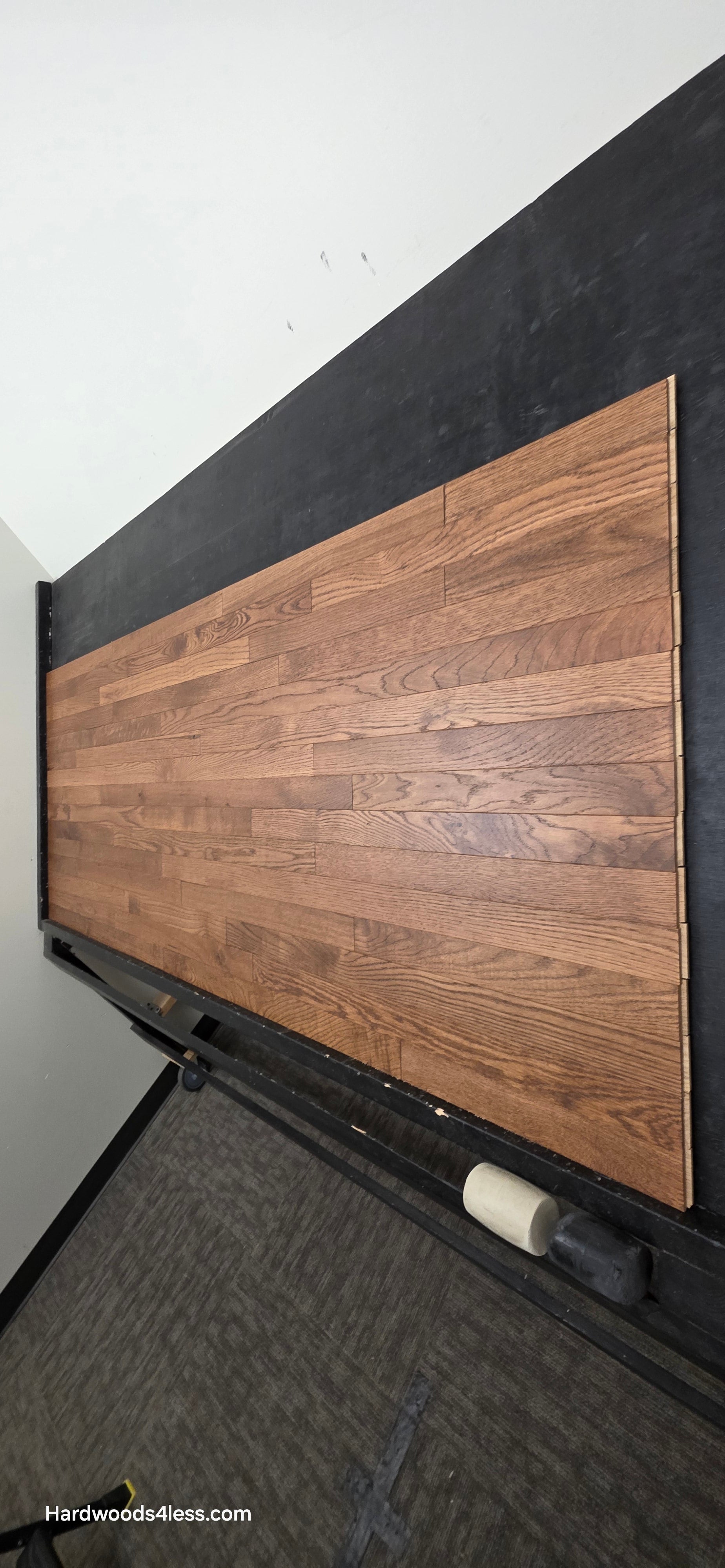 2 1/4" x 3/4" White Oak Gunstock Hardwood Flooring. Shown on a black shooting table. Shot from tight right.