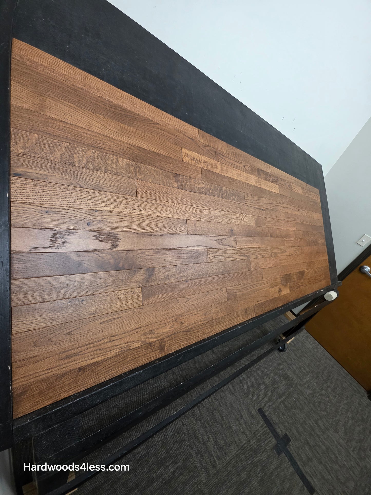 2 1/4" x 3/4" White Oak Gunstock Hardwood Flooring. Shown on a black shooting table. Shot from tight left.