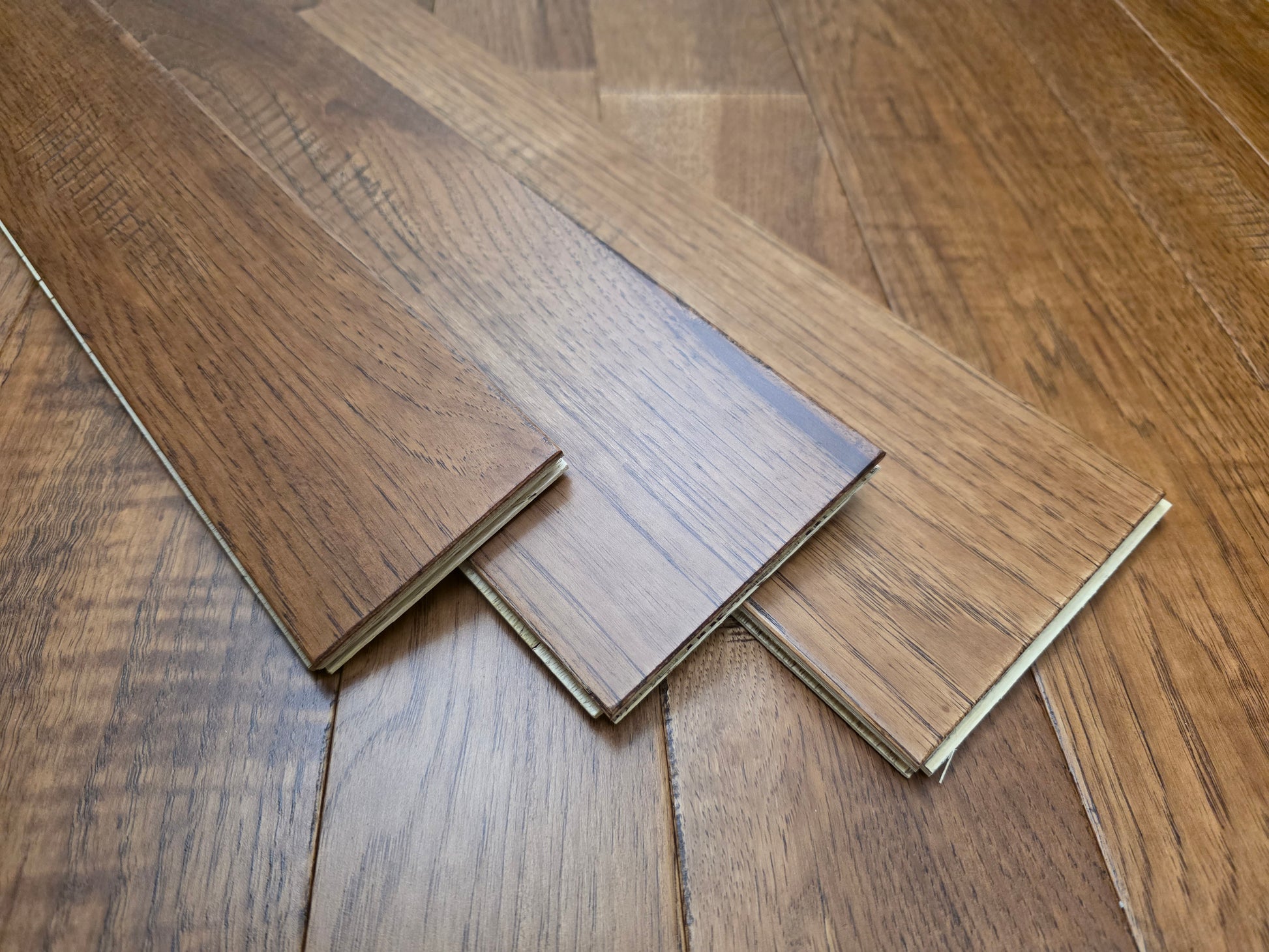 3 1/4", 4", 5" Mixed Width Engineered Hickory Regal Helm Hardwood Flooring. Shown on stacked as 3 on top of the flooring. 