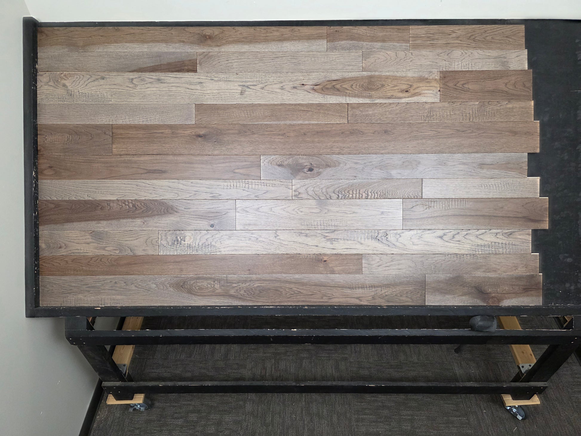 3 1/4", 4", 5" Mixed Width Engineered Hickory Windlass Hardwood Flooring. Shown on a Black shooting table front on.