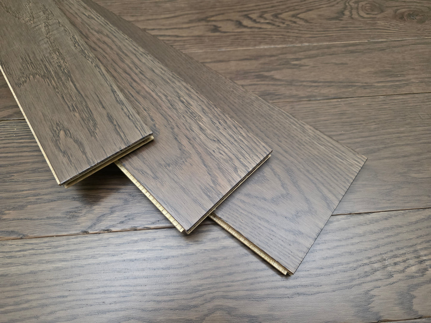 3 1/4", 4", 5" Mixed Width Engineered White Oak Transom Hardwood Flooring. Three planks are shown stacked on top of the floor at an angle. 