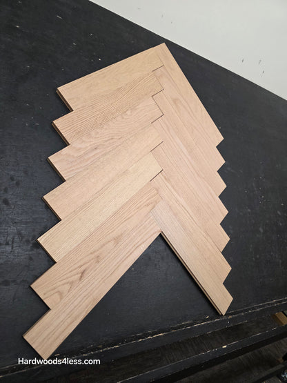 3 14 x 19 12 x 34 Solid Unfinished Red Oak Herringbone Hardwood Flooring. Shown on a black shooting table. Shot from steep left.