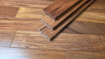 3 1/4" x 3/4" Brazilian Red Teak (Cumaru) Hardwood Flooring. In the center there are 3 planks stacked on top of each other. The planks are on top of the Brazilian cherry flooring.