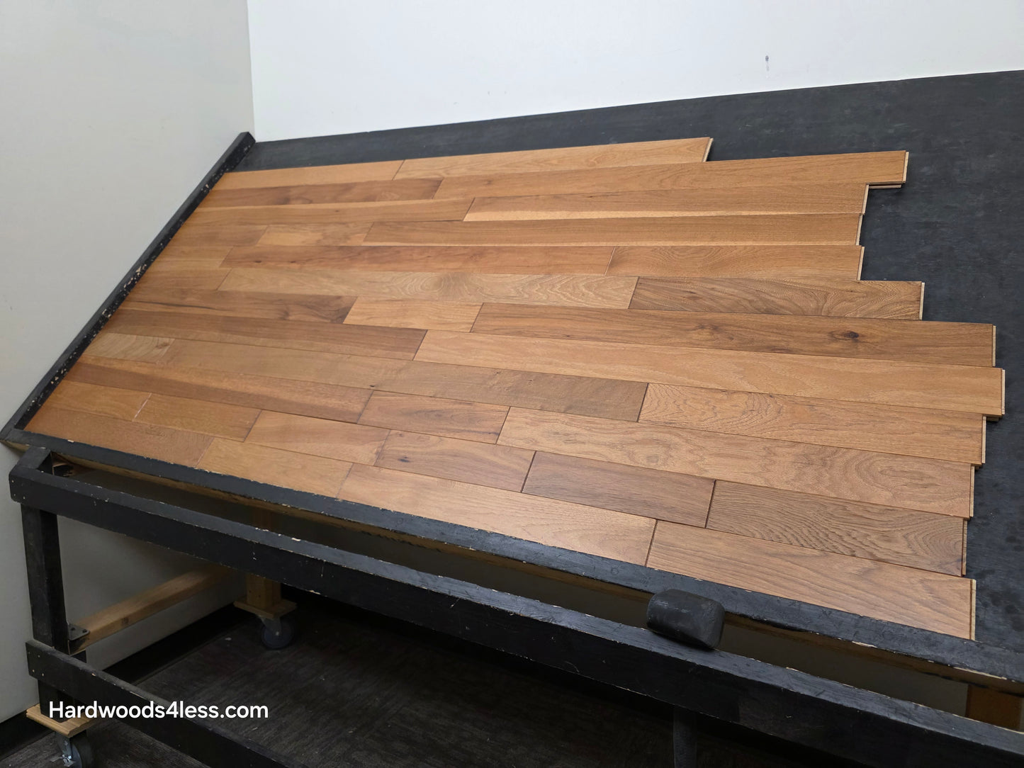 3 1/4" x 3/4" Hickory Molasses Character Grade Hardwood Flooring. Shown on a black shooting table. Shot from the right hand side. 