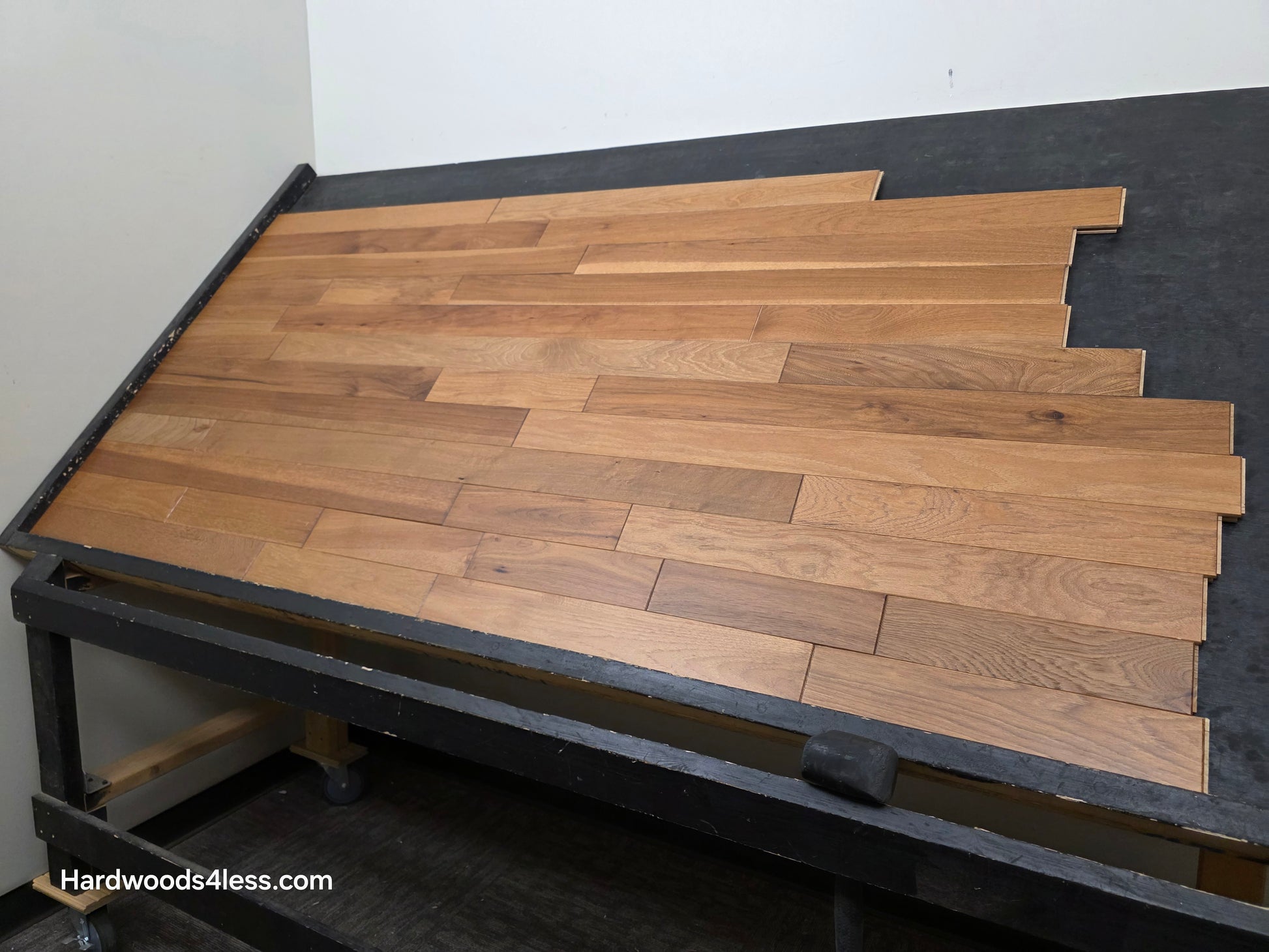 3 1/4" x 3/4" Hickory Molasses Character Grade Hardwood Flooring. Shown on a black shooting table. Shot from the right hand side. 