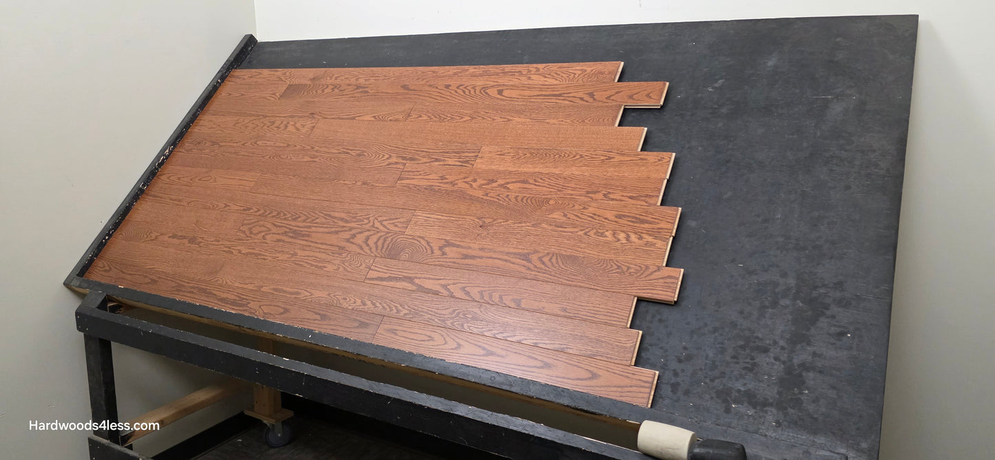 3 1/4" x 3/4" Red Oak Butterscotch Common & Better Hardwood Flooring. Shown on a black shooting table. Shot from wide right.