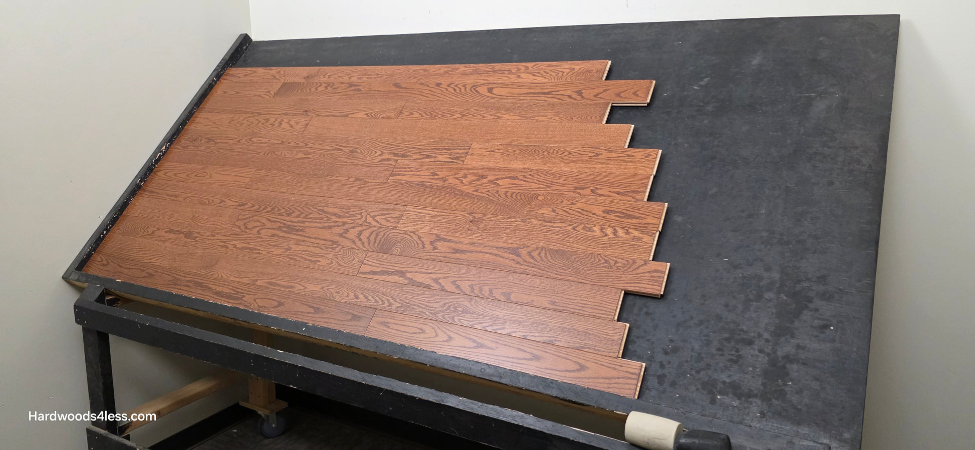 3 1/4" x 3/4" Red Oak Butterscotch Common & Better Hardwood Flooring. Shown on a black shooting table. Shot from wide right.