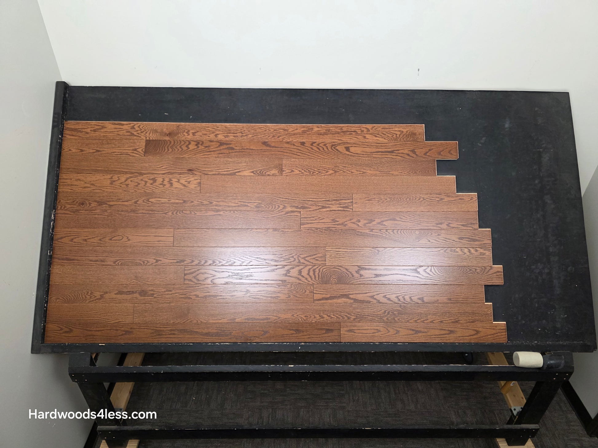 3 1/4" x 3/4" Red Oak Butterscotch Common & Better Hardwood Flooring. Shown on a black shooting table. Shot from center.