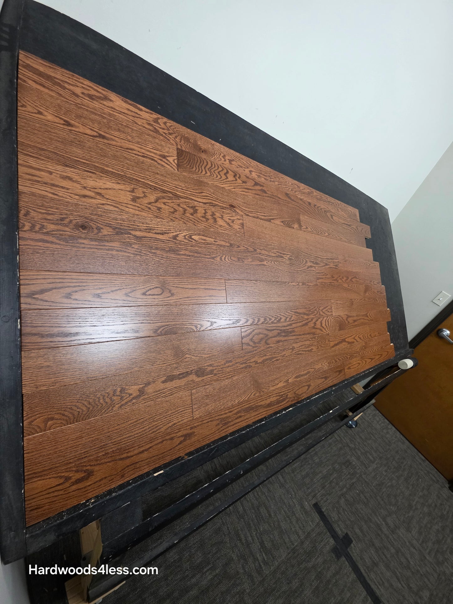3 1/4" x 3/4" Red Oak Butterscotch Common & Better Hardwood Flooring. Shown on a black shooting table. Shot from steep left. 