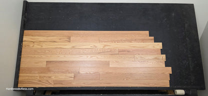 3 1/4" x 3/4" Red Oak Natural Common & Better Low Gloss Hardwood Flooring. Shown on a black shooting table. Shot from center.